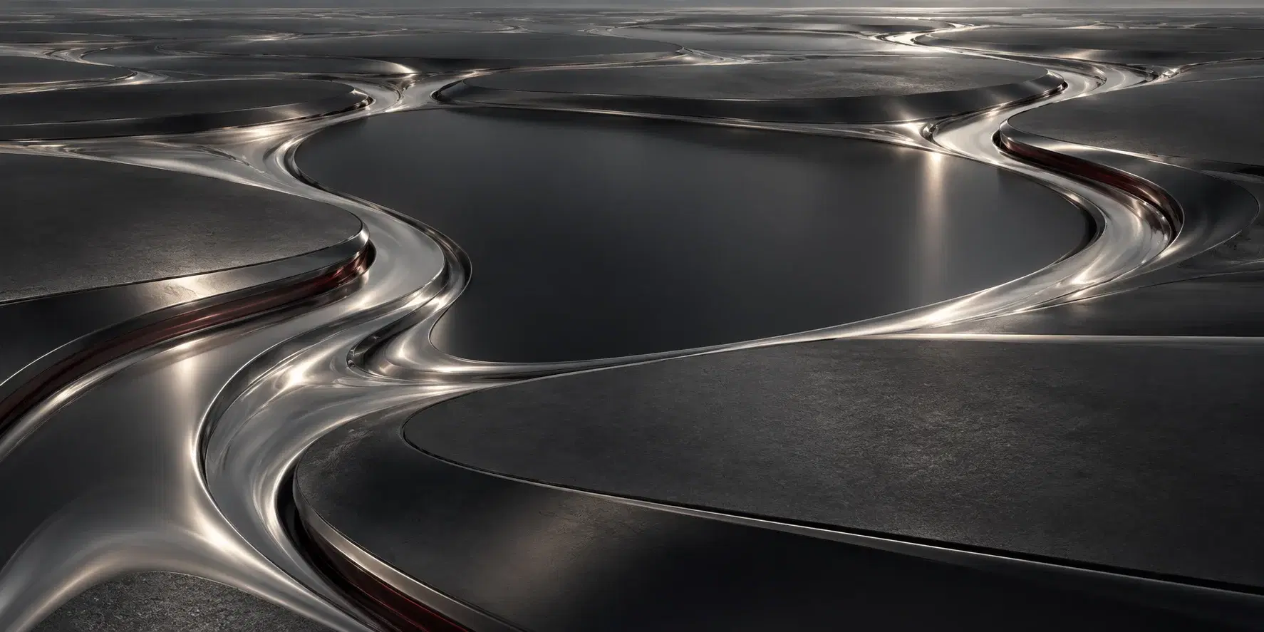 Smooth graphite terraces divide branching channels of reflective silver.